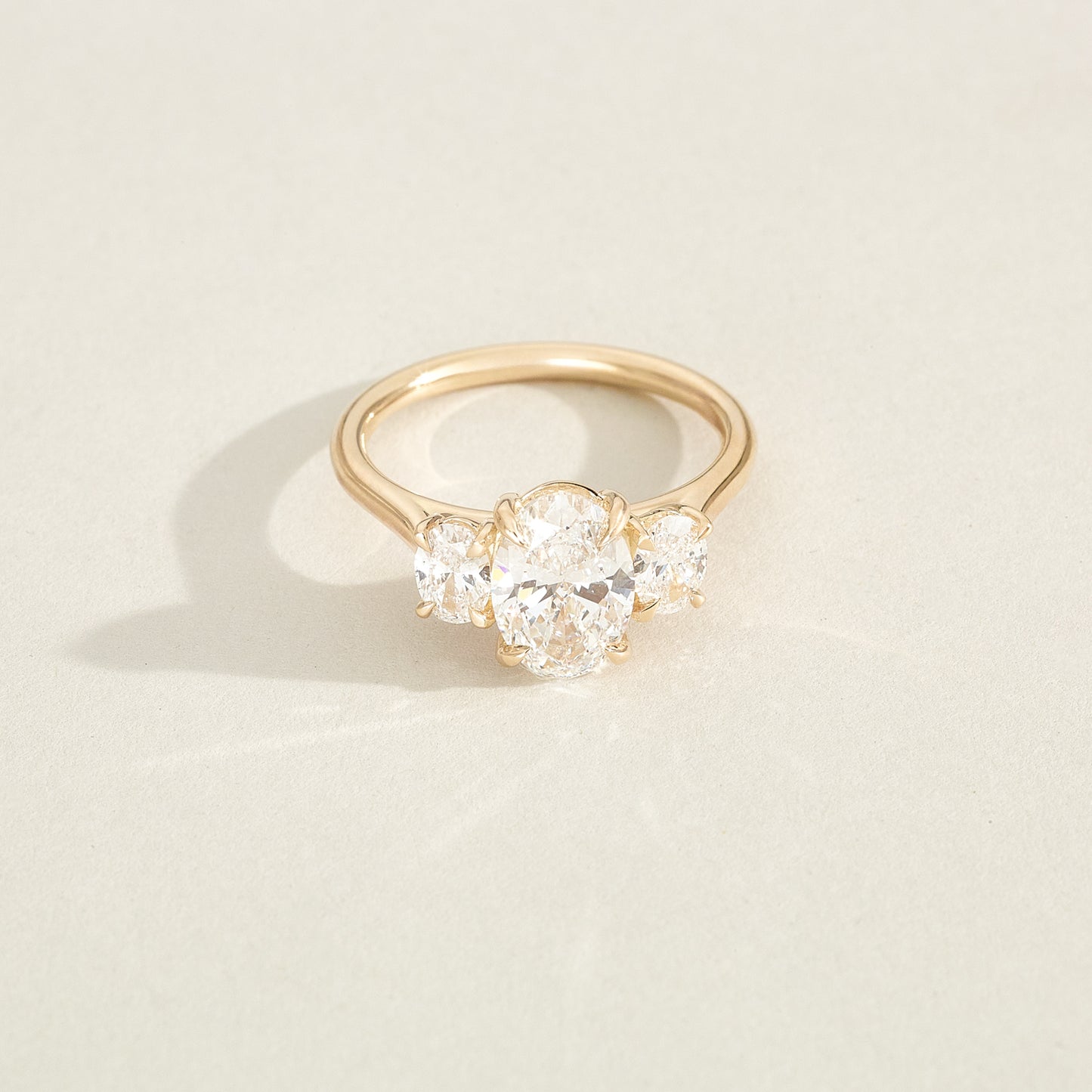 Gold ring with a diamond on a light beige background
