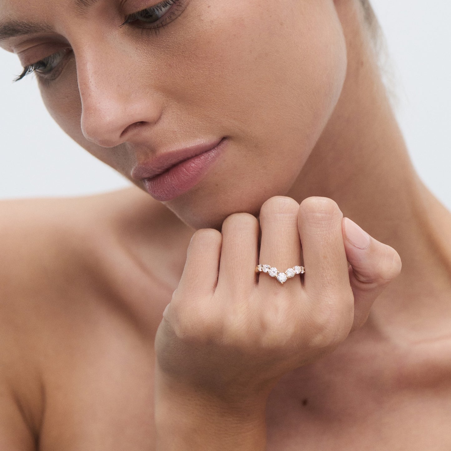 Woman elegantly showcasing a diamond ring on her finger, set against a light background. Luxurious jewellery style.
[text overlay: Size: Bold]