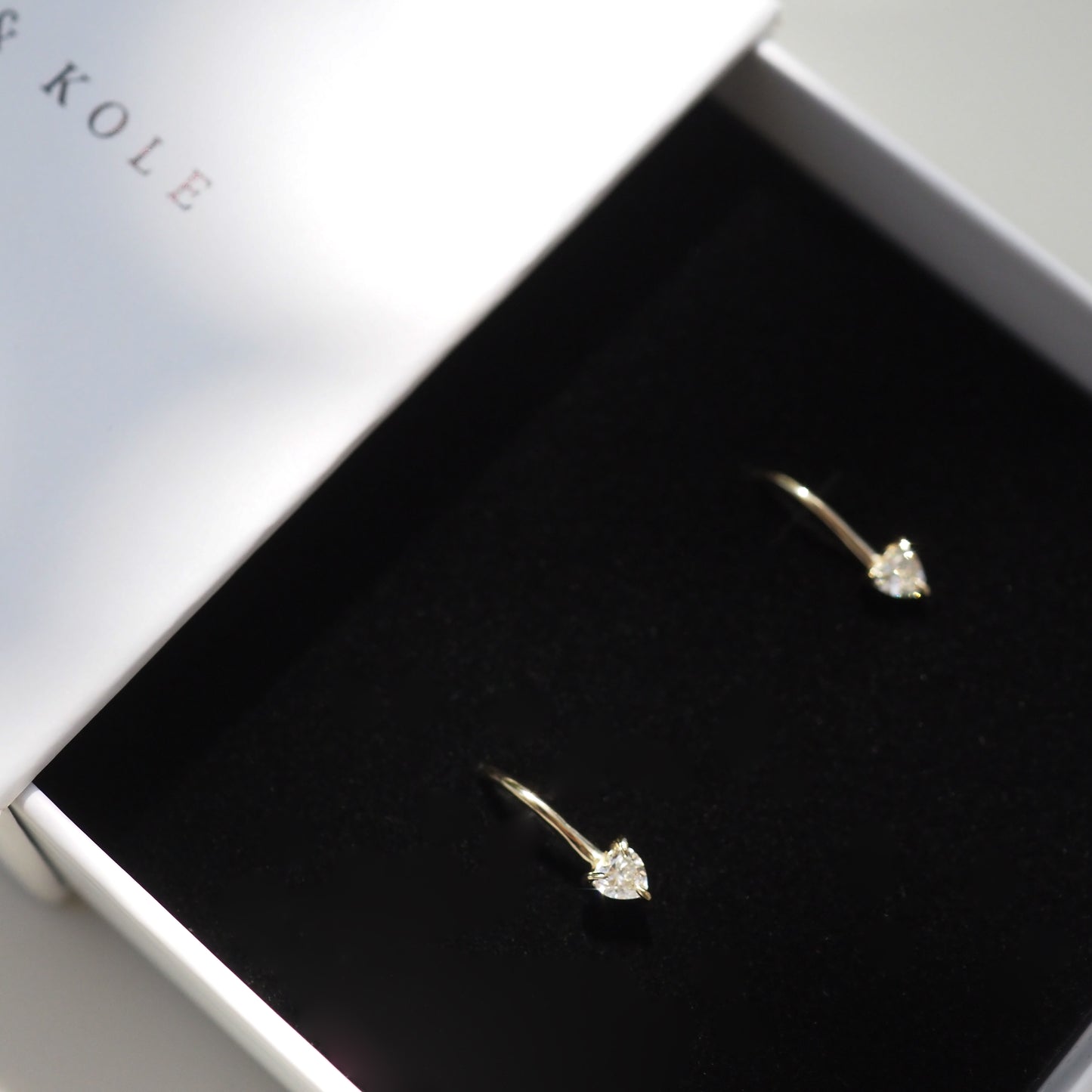 Elegant gold earrings with heart-shaped diamonds in a luxury gift box; ideal for high-end fashion and jewellery lovers.