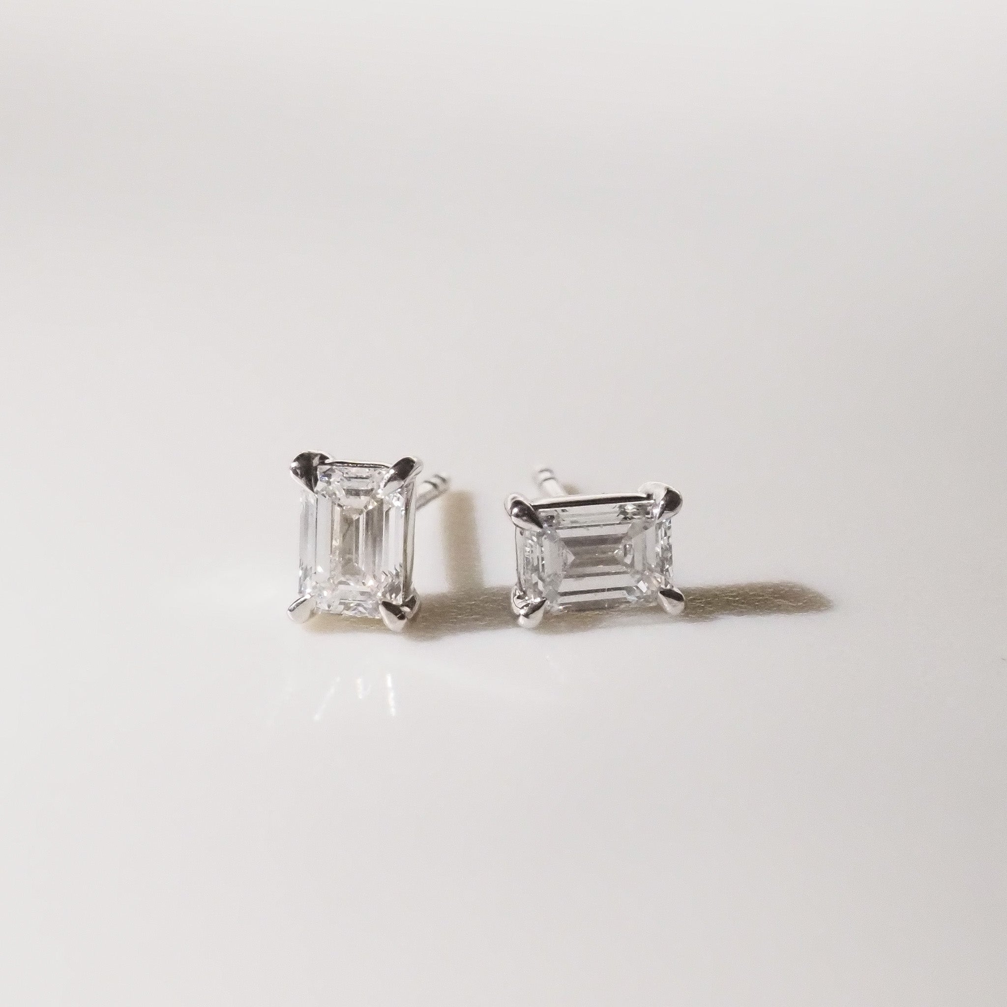 Pair of diamond stud earrings on a light gray background