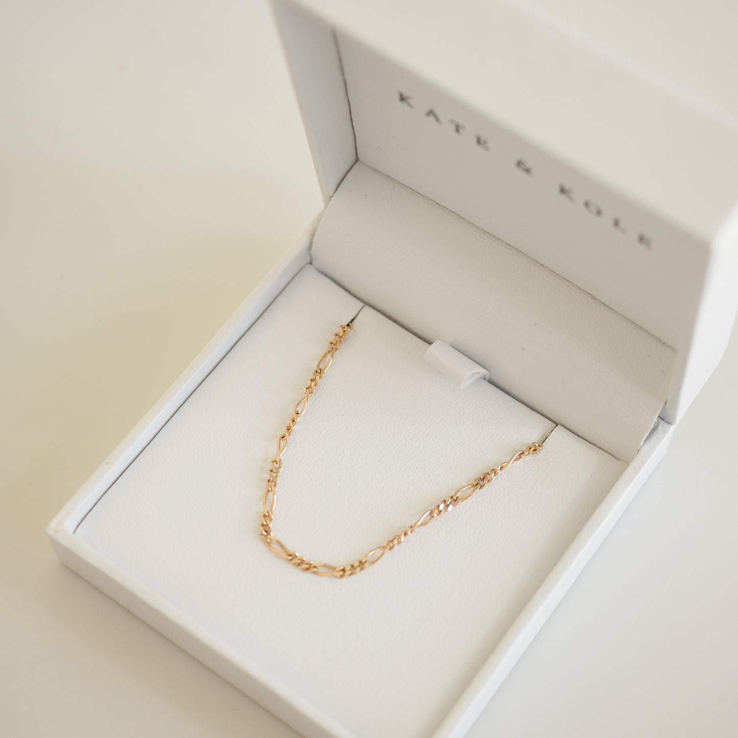 Delicate gold chain necklace in an open white Kate & Kole jewellery box, showcasing elegance and luxury craftsmanship.