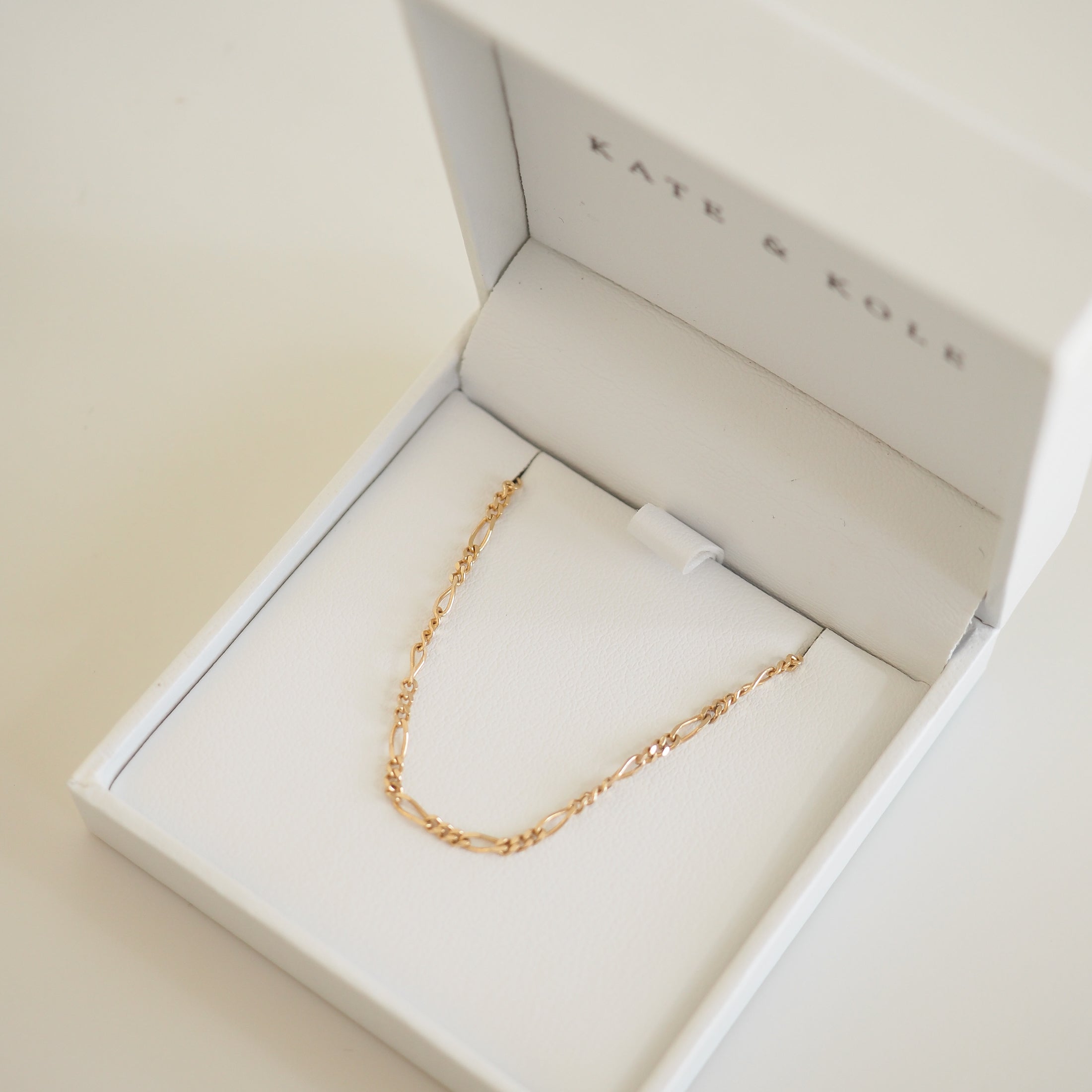 Delicate gold chain necklace in an open white Kate & Kole jewellery box, showcasing elegance and luxury craftsmanship.