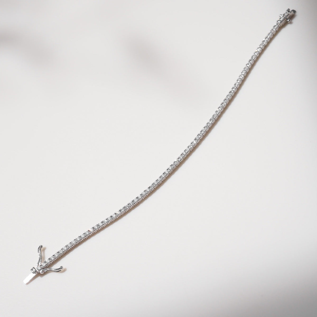 Silver bracelet with a clasp on a white background