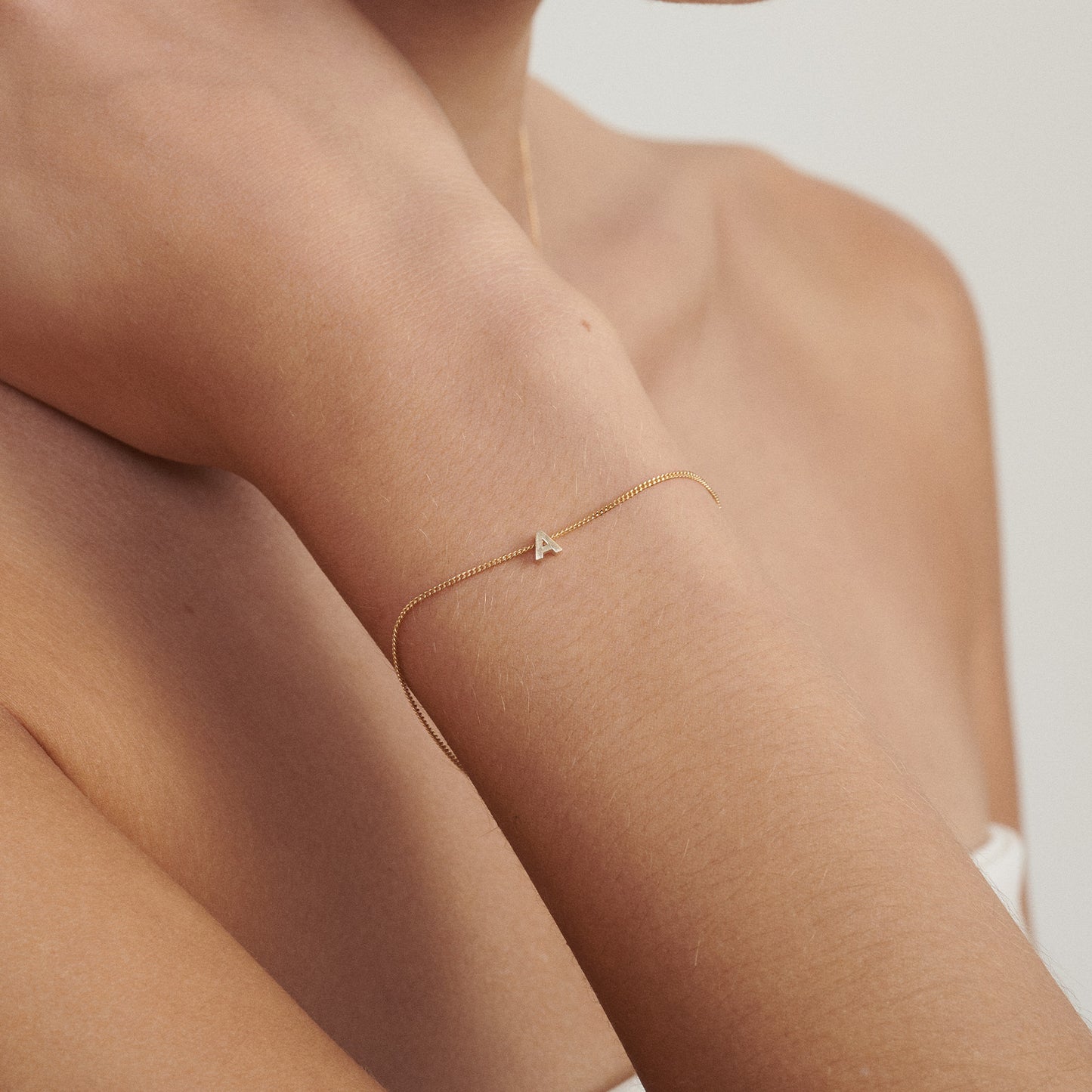Gold bracelet on a person's wrist with a blurred background