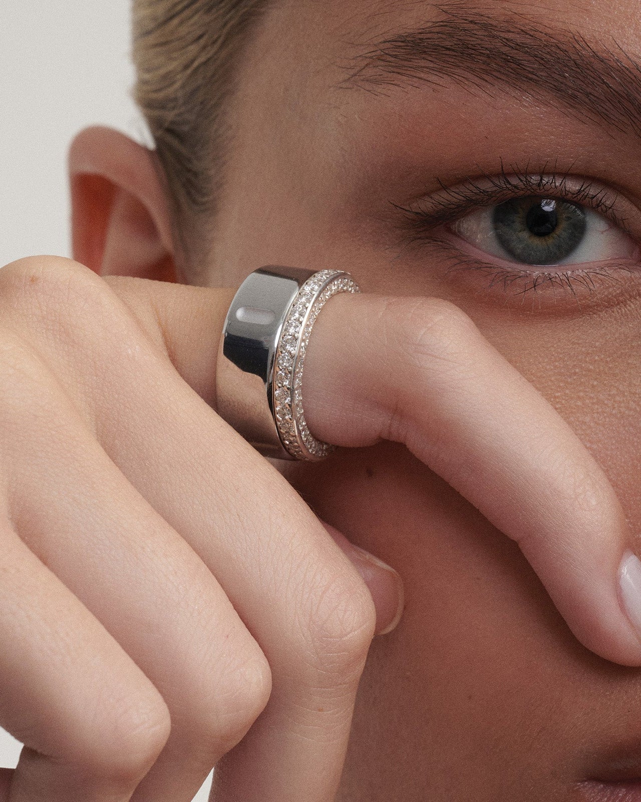 Close-up of a person wearing a white gold  ring on their finger alongside their Oura Ring