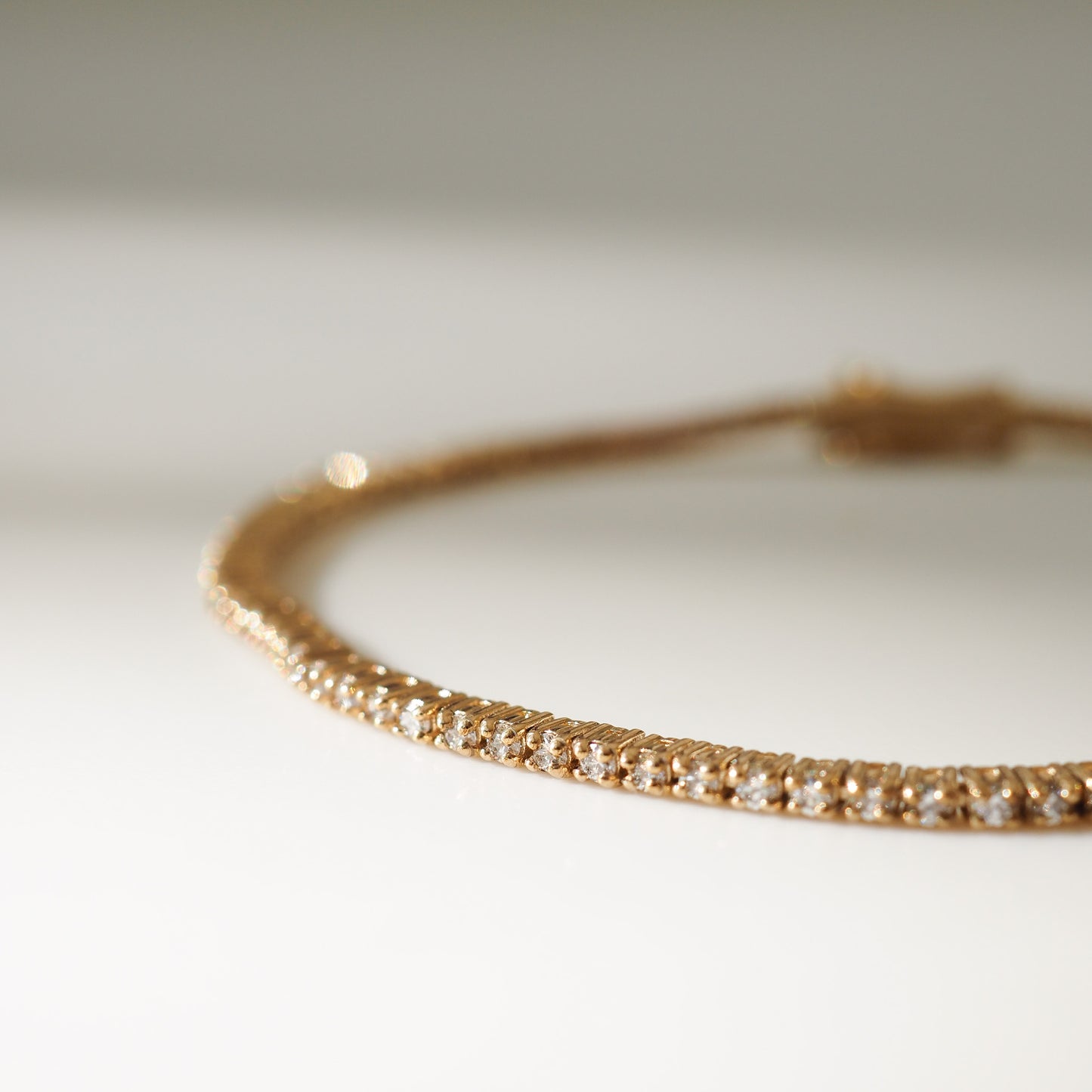 Gold bracelet with small diamonds on a light background