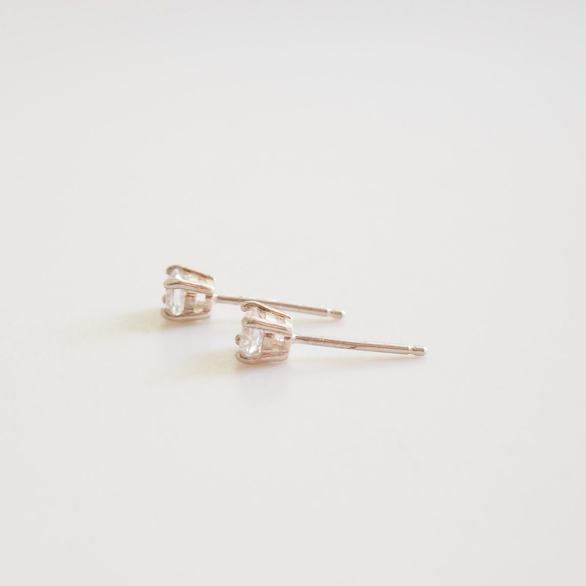 Pair of diamond stud earrings on a light background