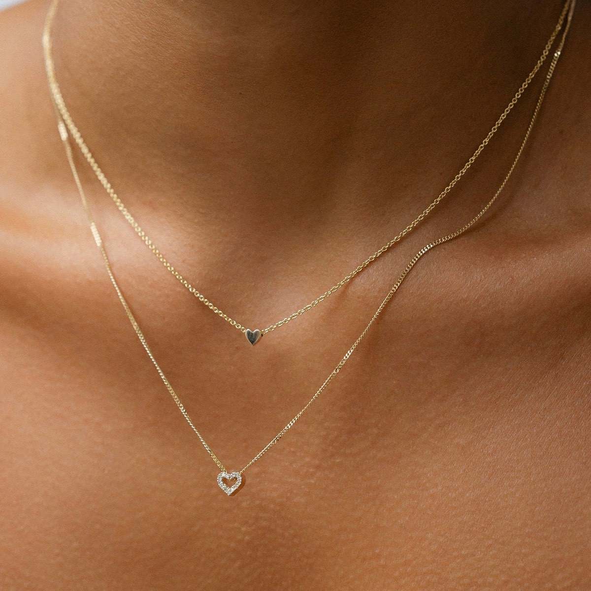 Model wears our beautiful Diamond Heart Charm Necklace in 9ct yellow gold, with a 45cm diamond curb chain layered with our 40cm solid gold Tiny Letter Necklace.