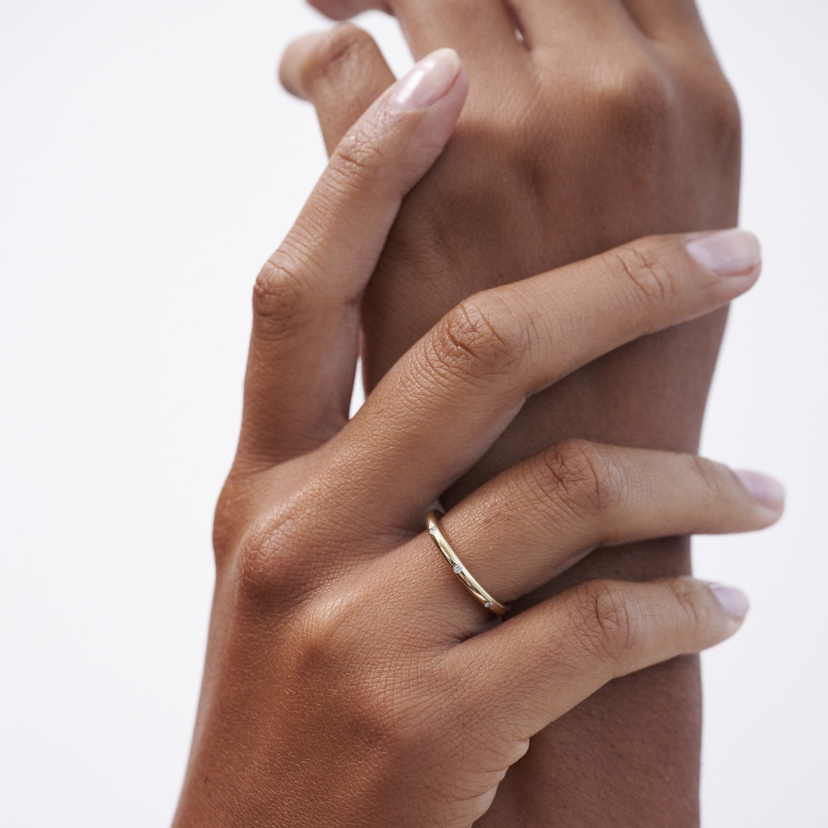 A solid gold round profile band for the modern minimalist — set with eight ornately set lab-grown diamonds spaced along the top or side edge.