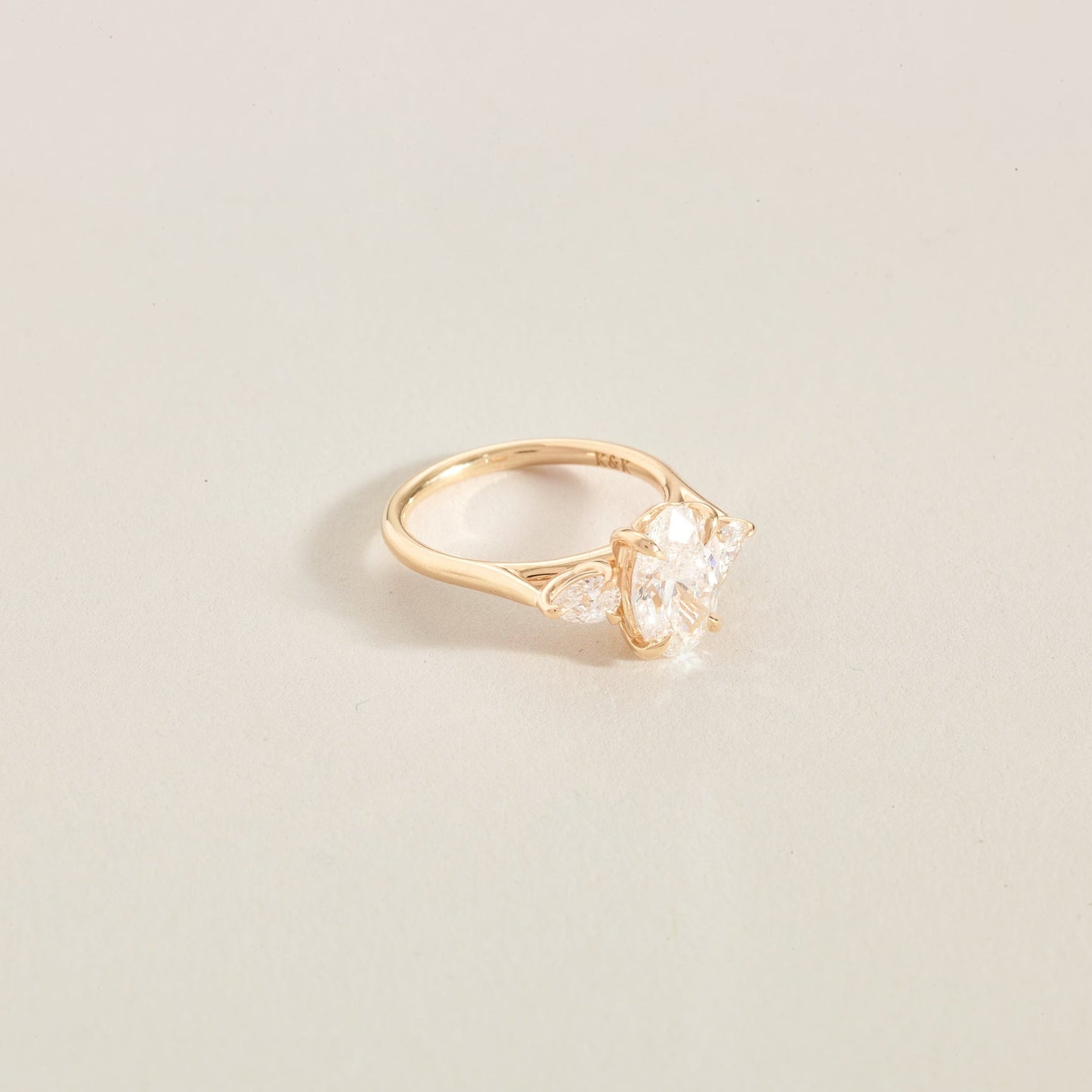 Gold ring with a 3 diamonds on a light beige background