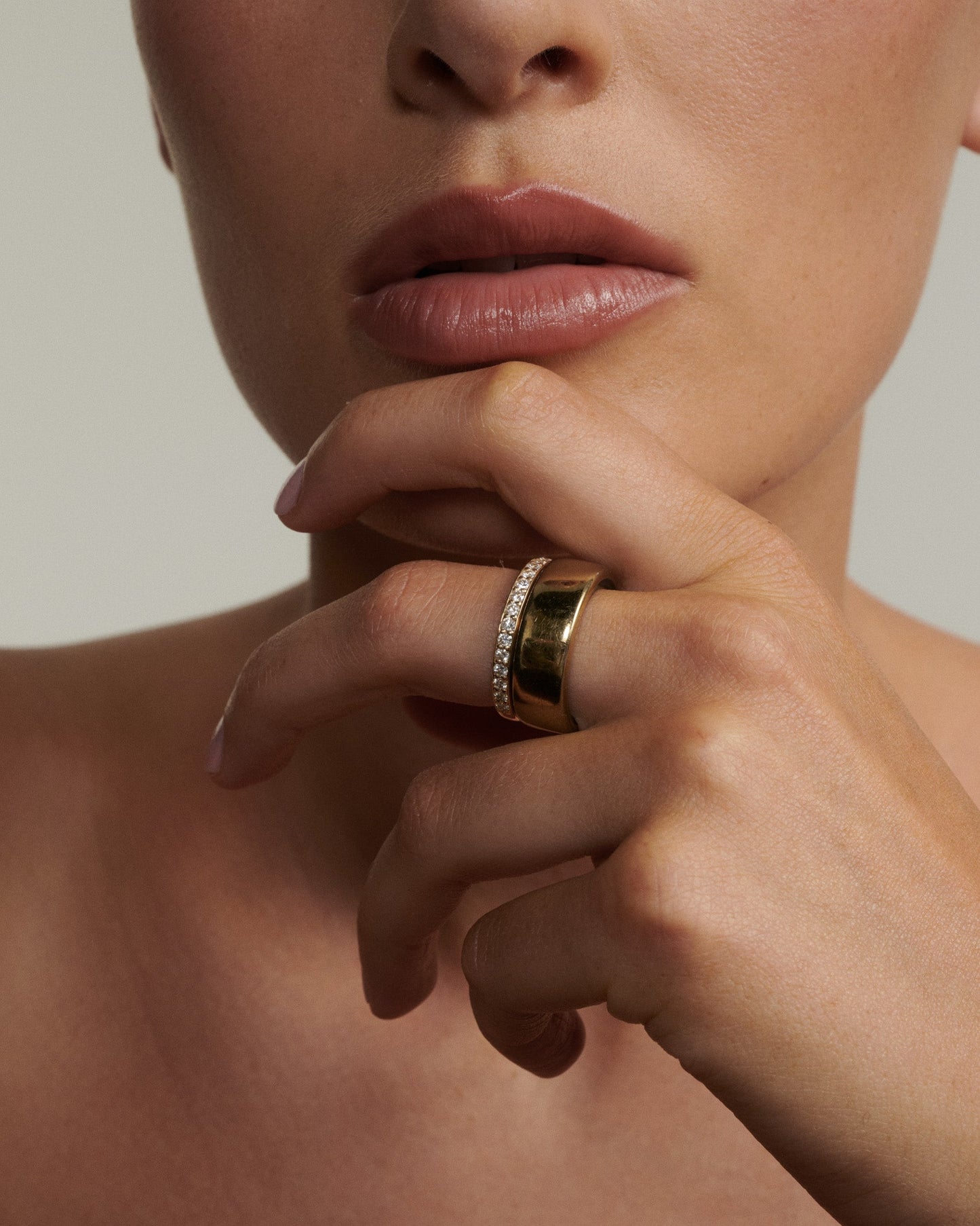 Close-up of a person wearing a gold ring on their finger