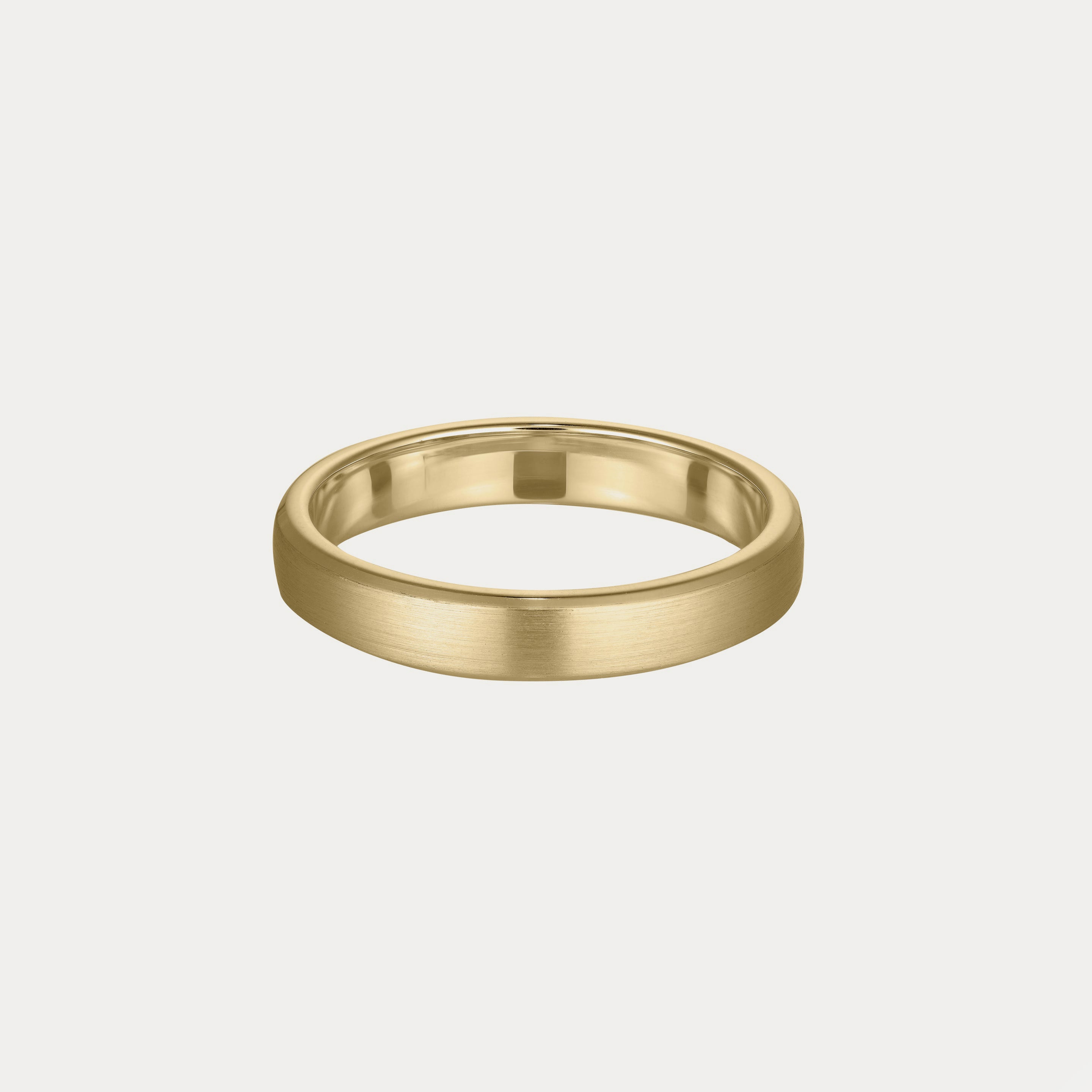Gold wedding band with a brushed matte finish, set against a plain off-white background. Classic and elegant luxury jewellery piece.