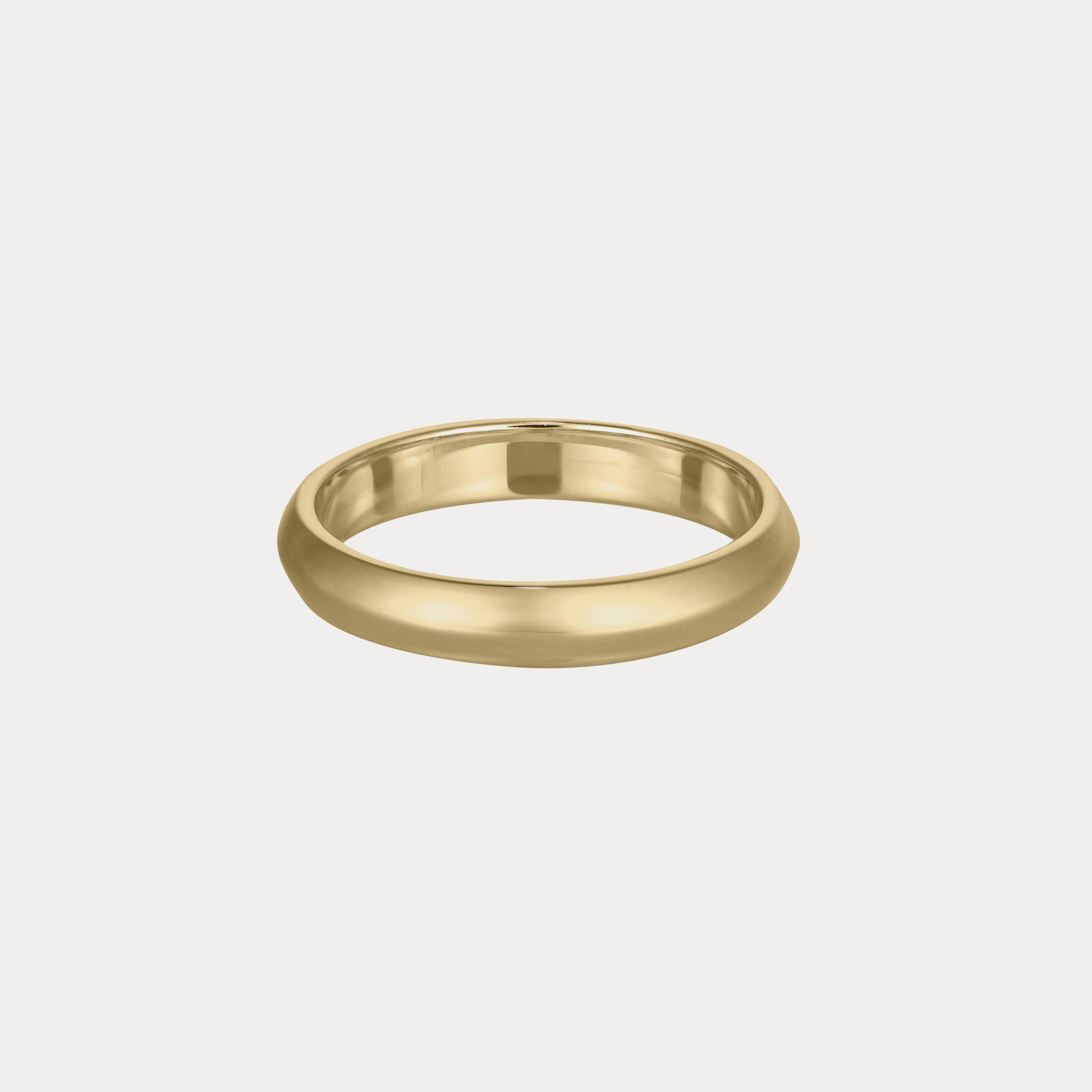 Sleek gold band ring on a plain background, showcasing its smooth, luxurious finish. Simple yet elegant design.