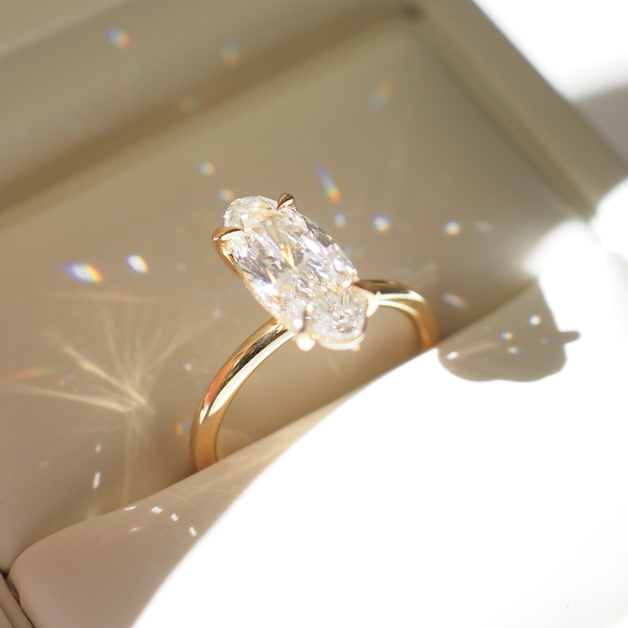 Gold ring with a Moval diamond on a light background
