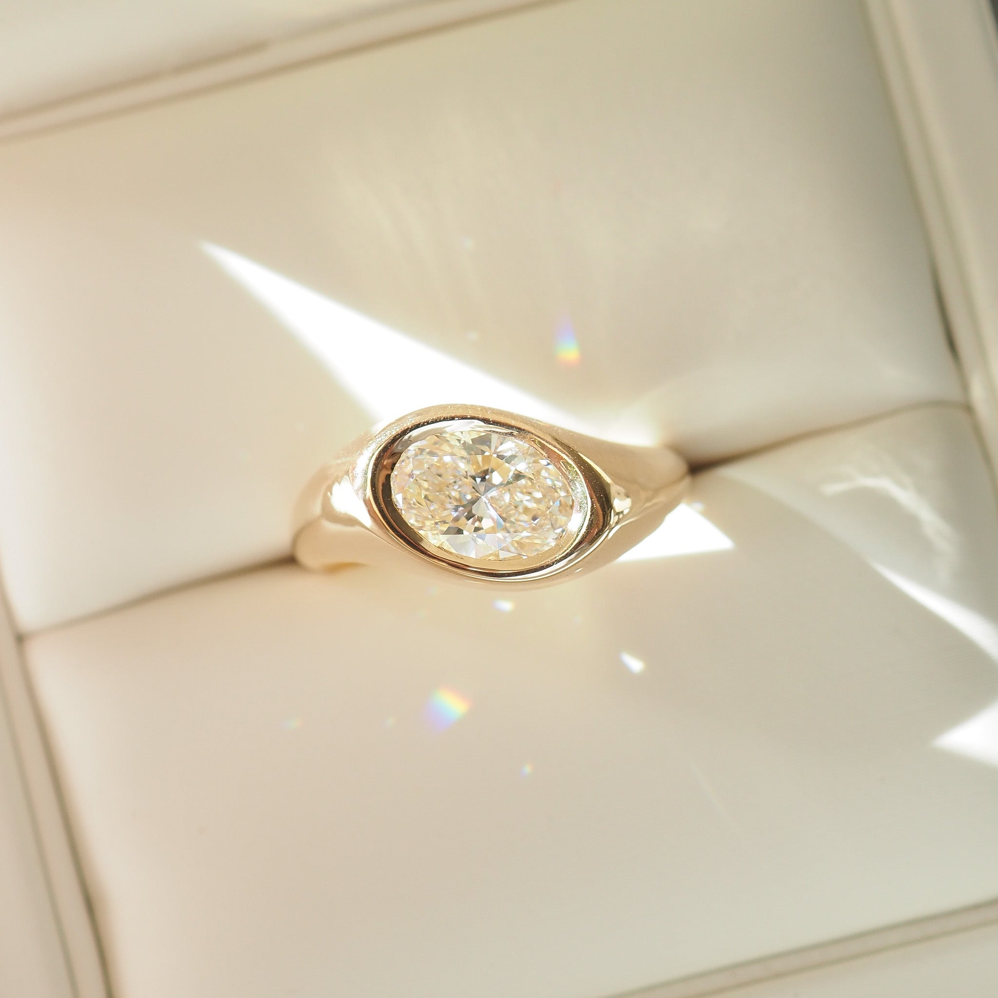Gold ring with a diamond on a white cushion