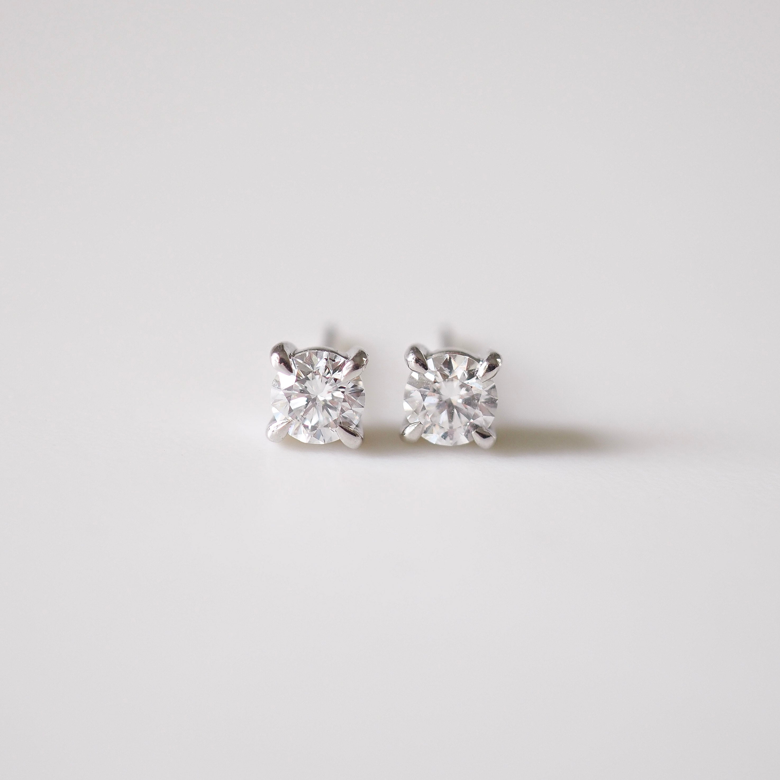 Pair of diamond stud earrings on a light gray background