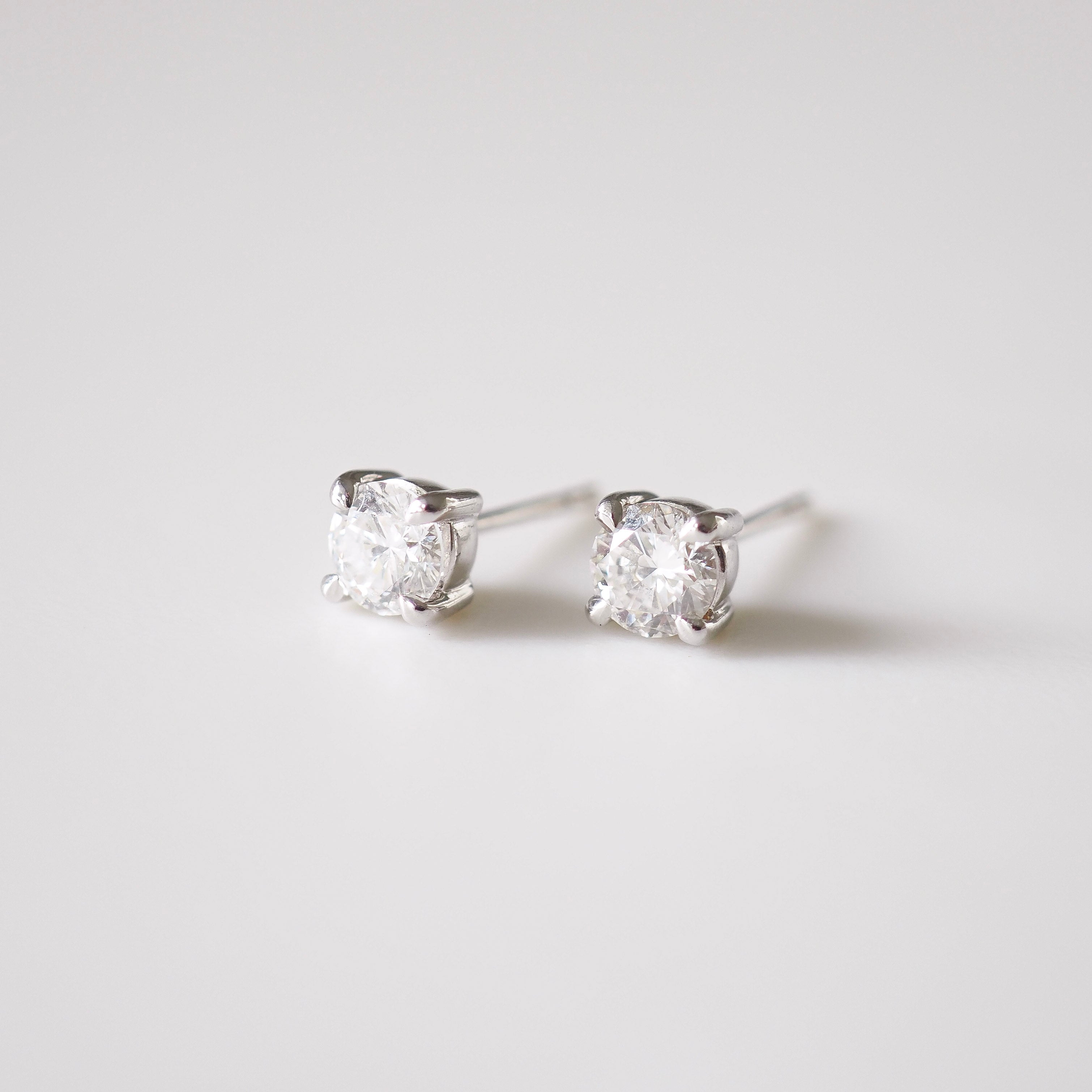 Pair of diamond stud earrings on a light gray background