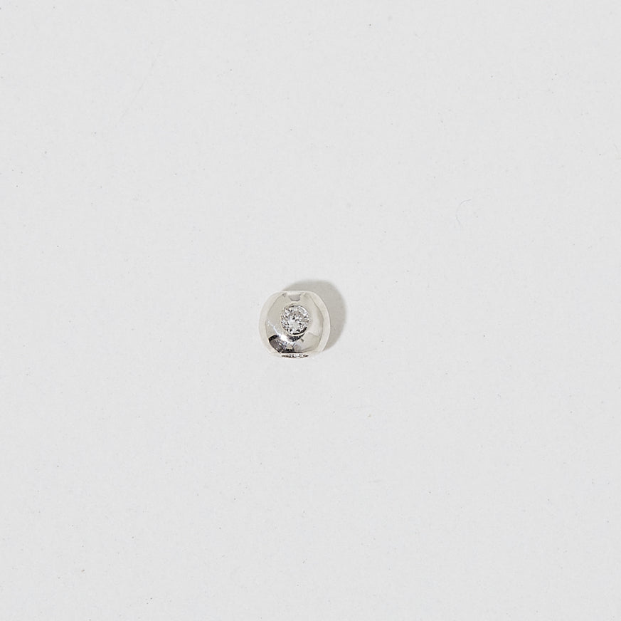 Round diamond bezel set stud earring on a plain white background, showcasing minimalist luxury jewellery design.
