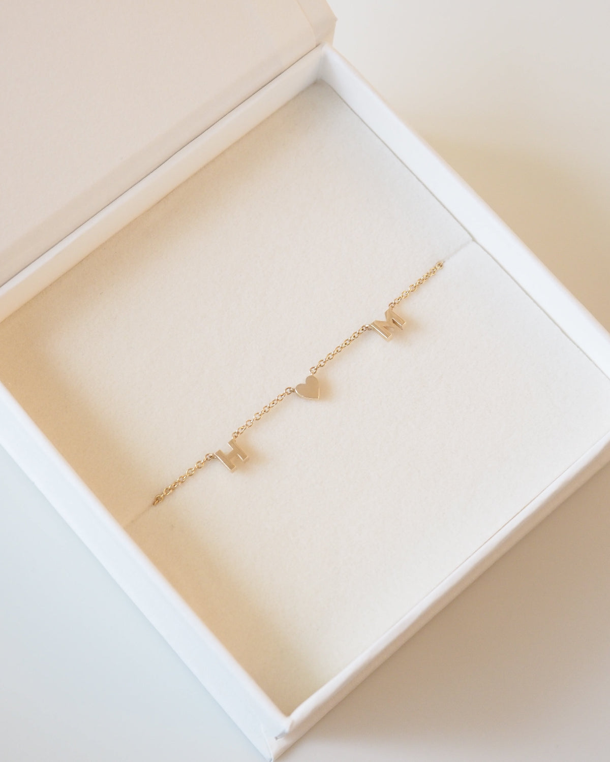 Gold necklace in an open jewelry box on a light beige background