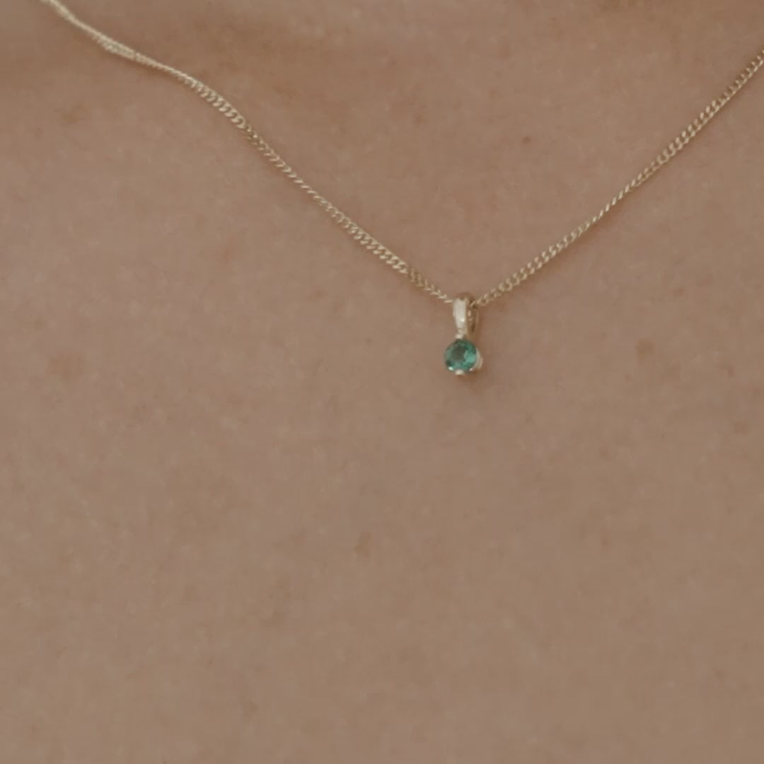 Video of a model wearing our 9ct yellow gold birthstone necklace with an emerald stone hung upon a 45cm diamond curb chain