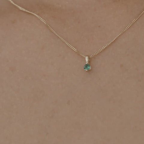 Video of a model wearing our 9ct yellow gold birthstone necklace with an emerald stone hung upon a 45cm diamond curb chain